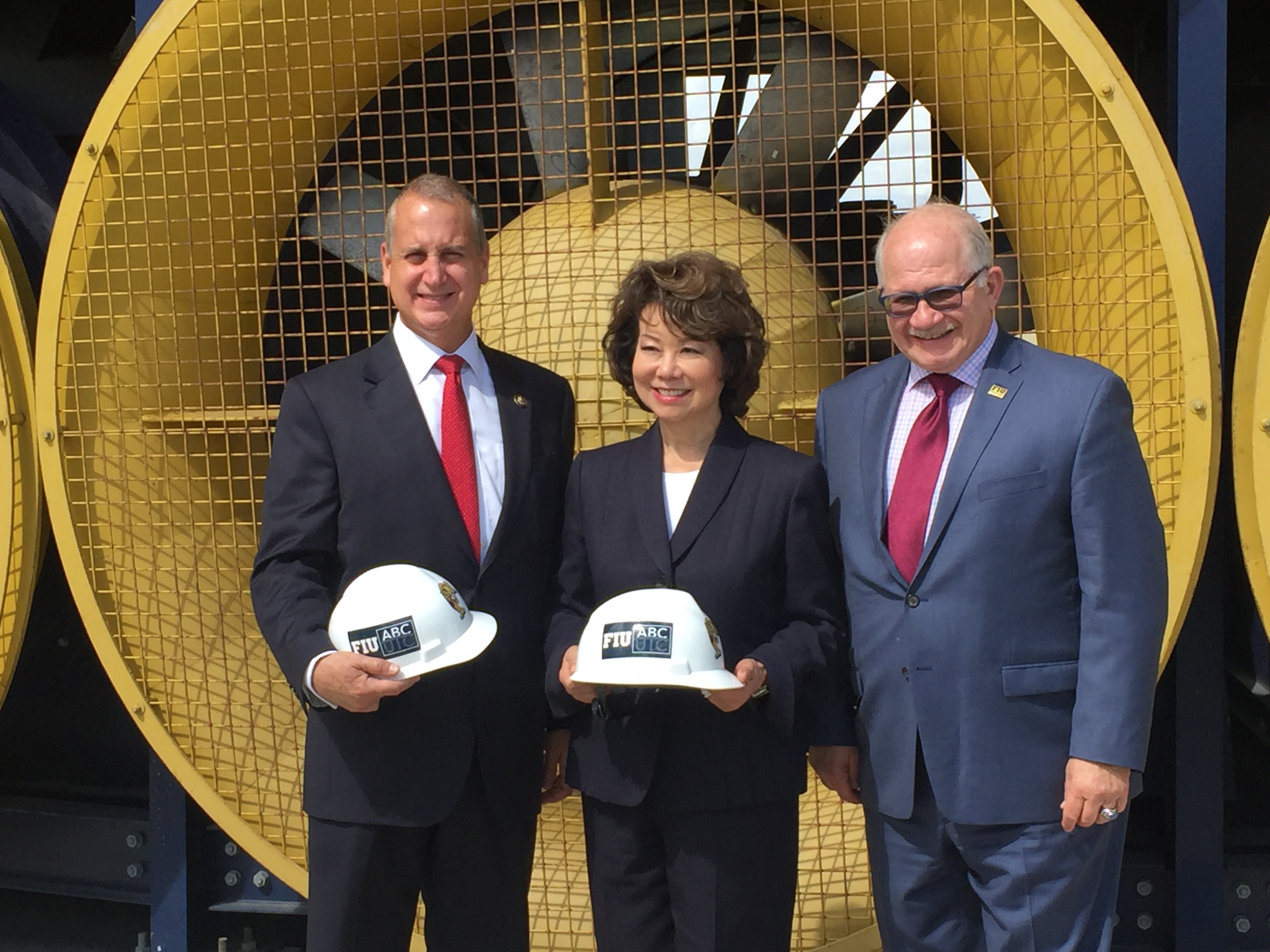 Congressman Diaz-Balart posing with others with construction hats