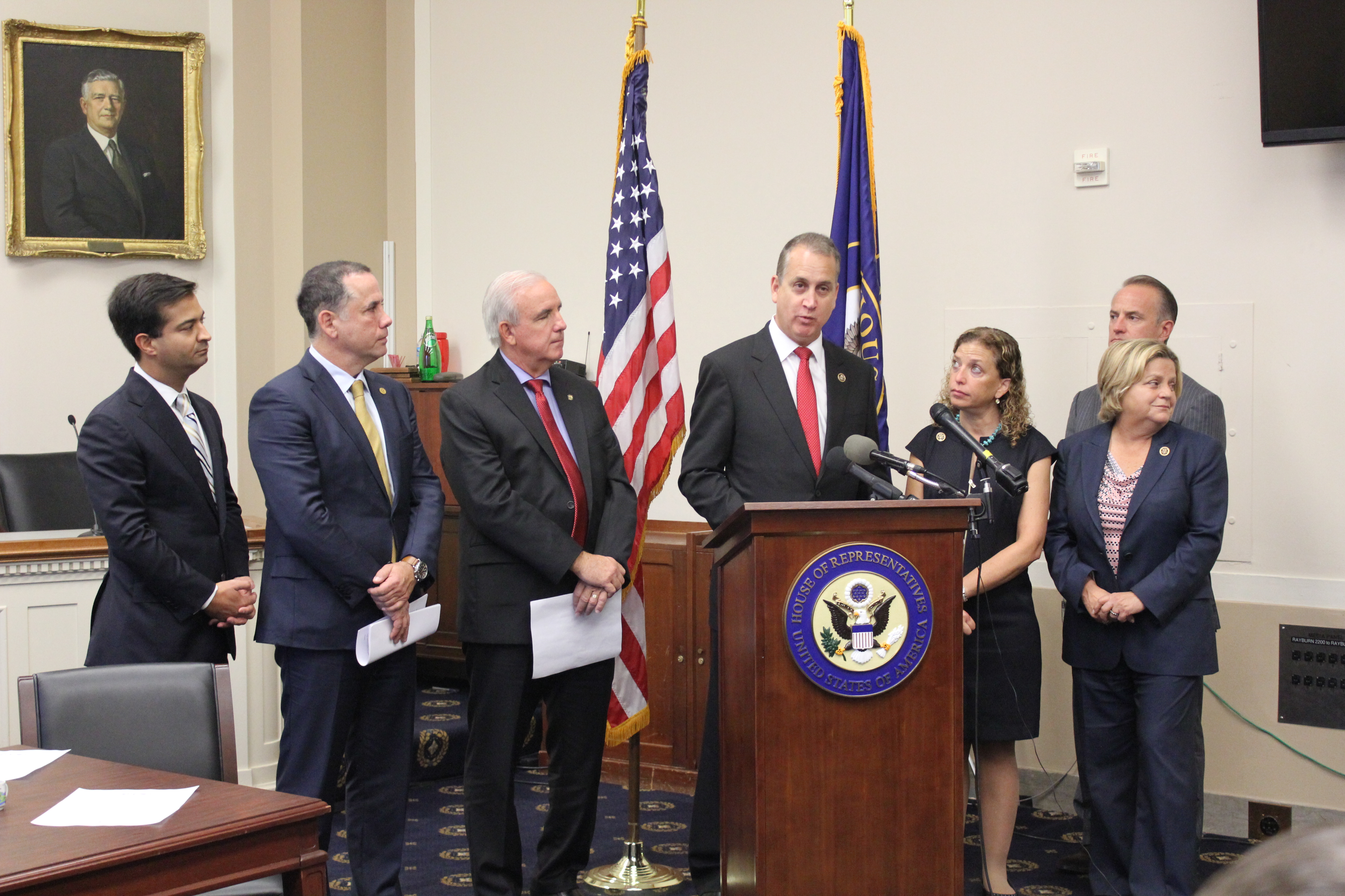 Congressman Diaz-Balart at podium posing with others