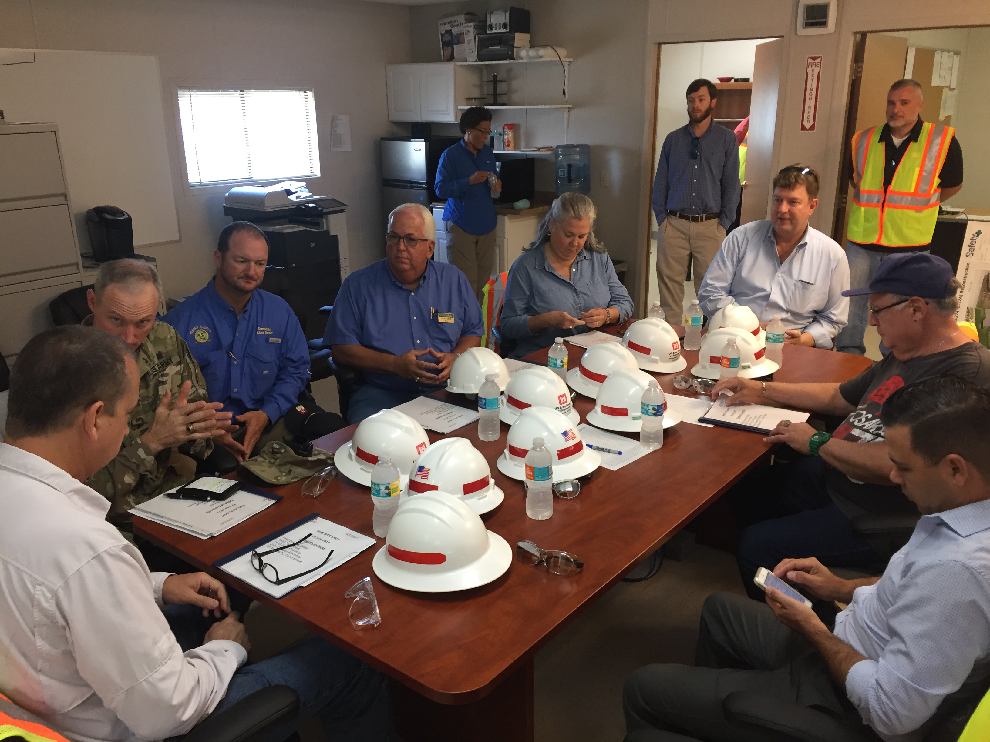 Congressman Diaz-Balart talk with people at a table