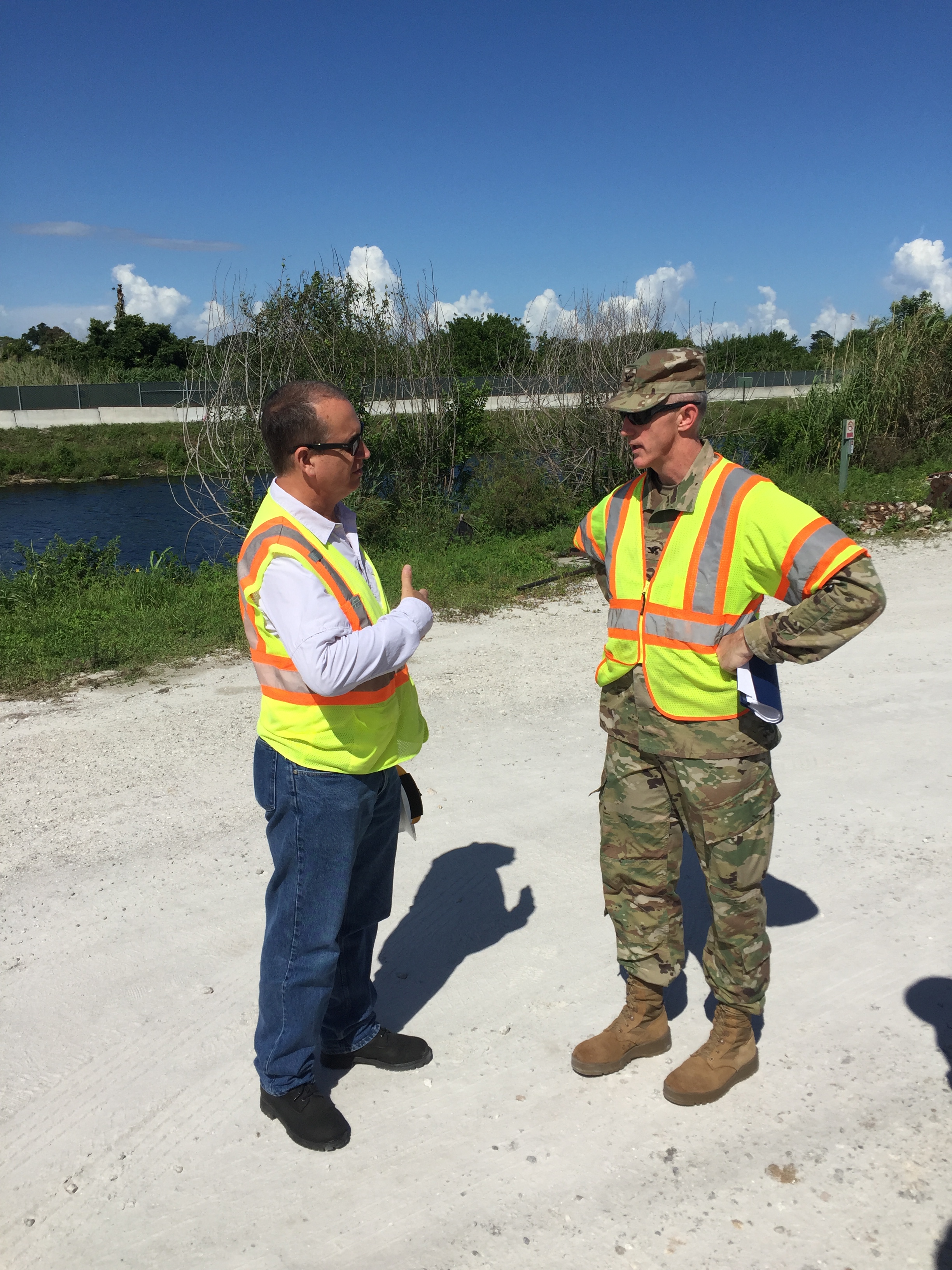 Congressman Diaz-Balart talking to a man in the field